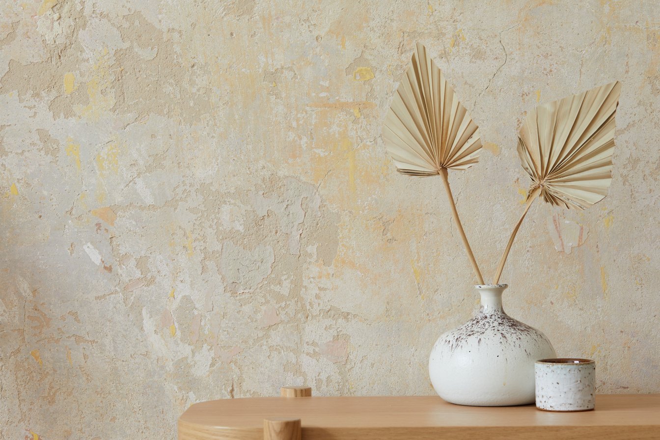 Wabi sabi interior of living room with wooden console, paper flowers in vase, accessories and copy space. Minimalistic concept. Template.